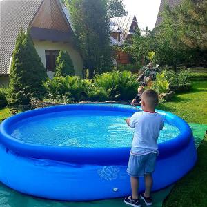 a young boy standing in front of a large blue pool at Willa Florynka in Biały Dunajec