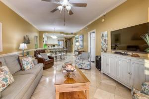 a living room with a couch and a tv at Enclave 1004 in Orange Beach