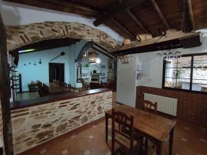 a dining room with a table and a stone wall at CASA RURAL LA CARRIONA in Segura de León