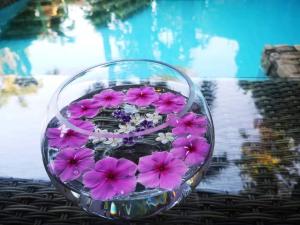 a glass bowl filled with purple flowers on a table at LePrive Resort in Pattaya South