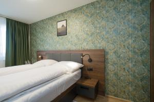 sypialnia z 2 łóżkami i niebieską tapetą w obiekcie MyApartments Vienna w Wiedniu