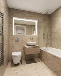 聖奧爾本斯的住宿－Abbott House by Viridian Apartments，浴室配有盥洗盆、卫生间和浴缸。