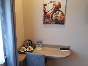 Ein Holztisch mit zwei Stühlen und ein Fahrrad an der Wand in der Unterkunft Pro B&B in Osielsko