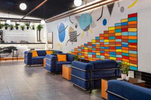 a waiting room with blue chairs and a colorful wall at One Shot Tabakalera House in Donostia-San Sebastián