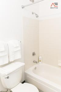 a white bathroom with a toilet and a bath tub at ENVITAE 3BR Spacious Lux Skyview Of Navy Pier in Chicago