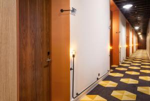 a hallway with yellow and white tiles on the floor at One Shot Tabakalera House in Donostia-San Sebastián