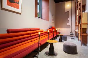 a room with a couch and some tables and stools at One Shot Tabakalera House in Donostia-San Sebastián