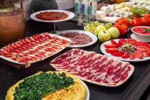 a buffet with many different types of meats and vegetables at One Shot Tabakalera House in Donostia-San Sebastián