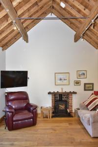 a living room with a leather chair and a fireplace at Finest Retreats - Shropshire Cottage, 2 bedrooms, sleeps 3 in Marchamley