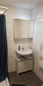 ein Bad mit einem Waschbecken und einem Spiegel in der Unterkunft andSleep in Mainz