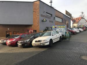 a row of parked cars parked in front of a hotel at Hotel Taurus in Ostrava