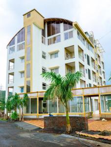 a tall building with a palm tree in front of it at Bodh Valley Resort in Igatpuri