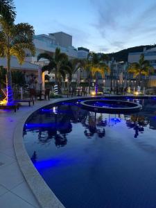 una piscina con luces azules en un complejo en Apartamento Praia Norte Ingleses, en Florianópolis