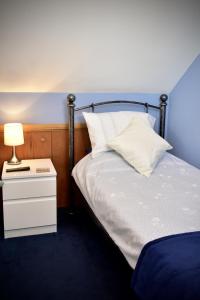 Finest Retreats - Shropshire Cottage, 2 bedrooms, sleeps 3 في Marchamley: غرفة نوم مع سرير وطاولة مع مصباح