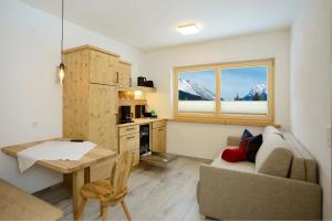 a living room with a couch and a table and a kitchen at Birklstüberl Restaurant und Appartement in Seefeld in Tirol