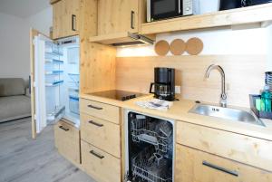 a kitchen with a sink and a dishwasher at Birklstüberl Restaurant und Appartement in Seefeld in Tirol