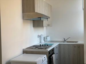 a small kitchen with a stove and a sink at Carvetii - Edward House B - 2 Dbl bed 1st floor flat in Dunfermline