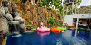 a pool with two pink flamingos in the water at Lovina Central Hostel in Lovina