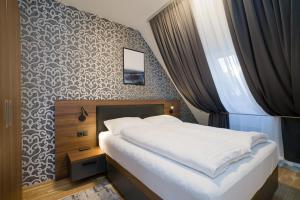 sypialnia z łóżkiem i ścianą w obiekcie MyApartments Vienna w Wiedniu