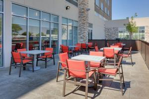 a patio with tables and chairs in front of a building at Holiday Inn Express & Suites - Dallas NW HWY - Love Field, an IHG Hotel in Dallas