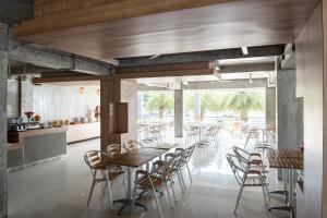 a dining room with wooden tables and chairs at Eco Inn Lite Ubon Ratchathani in Ubon Ratchathani