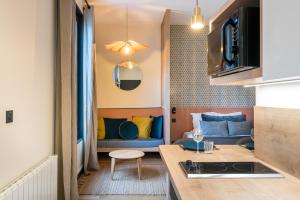 een keuken en een woonkamer met een bank in een kamer bij HONORÊ - SUITE ARBRE SEC in Lyon