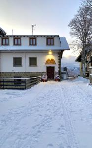 una casa nella neve con le impronte nella neve di B&B Dahu ad Abetone