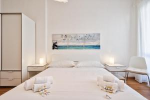 - une chambre blanche avec un lit et deux chaises dans l'établissement Toc-Toc Apartment a 10 min dall'Ospedale Maria Vittoria, à Turin