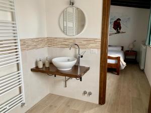 un bagno con lavandino, specchio e letto di B&B Dahu ad Abetone