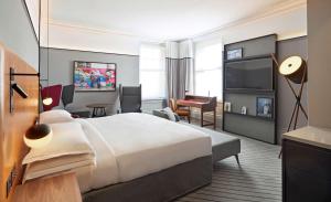 ロンドンにあるアンダズ ロンドン リバプール ストリート ア コンセプト バイ ハイアットの大型ベッドとテレビが備わるホテルルームです。