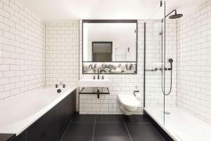 a bathroom with a tub and a toilet and a sink at Andaz London Liverpool Street, By Hyatt in London +54 photos