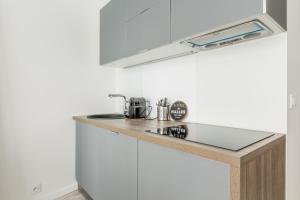 a kitchen with white cabinets and a counter top at GuestReady - Stunning Apartment near EIFFEL TOWER in Paris