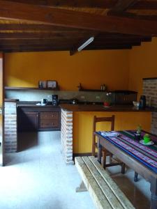 - une cuisine avec une table et un banc dans une pièce dans l'établissement Casa Fortaleza Hostel, à San Bernardo