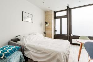 a bedroom with a bed and a desk and a window at GuestReady - Stunning Apartment near EIFFEL TOWER in Paris