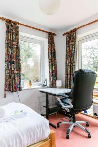 1 dormitorio con escritorio y silla frente a una ventana en Pass the Keys Cosy & Bright Studio with Garden View Free Parking, en Cambridge