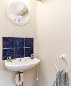 a white bathroom with a sink and a mirror at Pass the Keys Cosy & Bright Studio with Garden View Free Parking in Cambridge