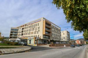 un gran edificio en una calle de la ciudad con una carretera en Студия и Стаи за гости -жк Пентагон, en Kardzhali