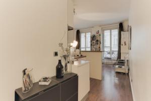 a kitchen with white walls and a wooden floor at GuestReady - Artsy Flat for 2 near Opera in Paris