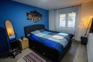 Dormitorio azul con cama y espejo en 7 Days Premium Apartment, en Subotica
