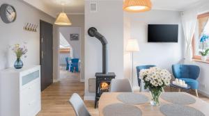 考斯賽力克的住宿－TWOJA CHATA Apartamenty pod niebem，客厅配有桌子和燃木炉。