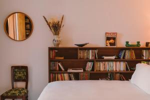 a bedroom with a book shelf filled with dvds at HOTEL AMOUR NICE in Nice