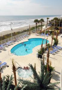 a pool with people in it next to the beach at Sandy Beach Resort in Myrtle Beach