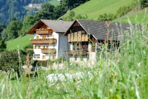 une maison au milieu d'un champ verdoyant dans l'établissement HAUSERHOF - Urlaub auf dem Bauernhof in Villanders mit einzigartigem Ausblick in die Dolomiten, à Villandro