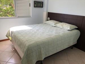 1 cama grande en un dormitorio con ventana en JURERE INTERNACIONAL COSTA BLANCA, en Florianópolis