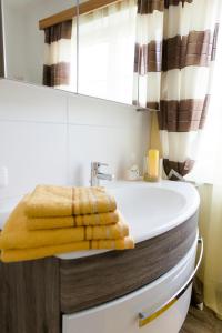ein Badezimmer mit einer Badewanne und einem gelben Handtuch darauf in der Unterkunft Wohnung am See in Steinbach am Attersee