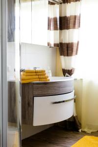 a bathroom with a sink and a counter with towels at Wohnung am See in Steinbach am Attersee