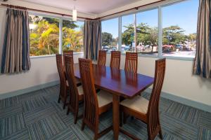 a dining room with a table and chairs and windows at Time Out Hotel in Christ Church