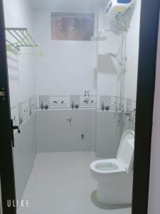 La salle de bains blanche est pourvue d'une douche et de toilettes. dans l'établissement Starlet Hotel Phong Nha, à Phong Nha
