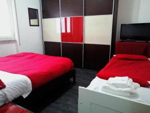 Zimmer mit 2 Betten in Rot und Weiß in der Unterkunft APT. Re Nasone in Caserta