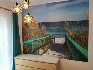 a room with a painting of the beach at Apartament Przytulny Podolany in Poznań